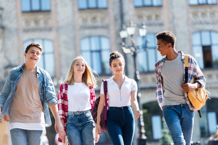 Teens with backpacks walking on a college campus