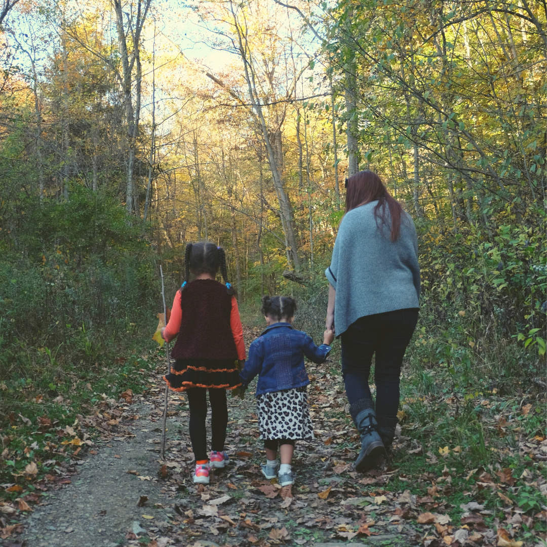 A mother and two daughters hold hands and explore a trail in WPC's Toms Run Nature Reserve.