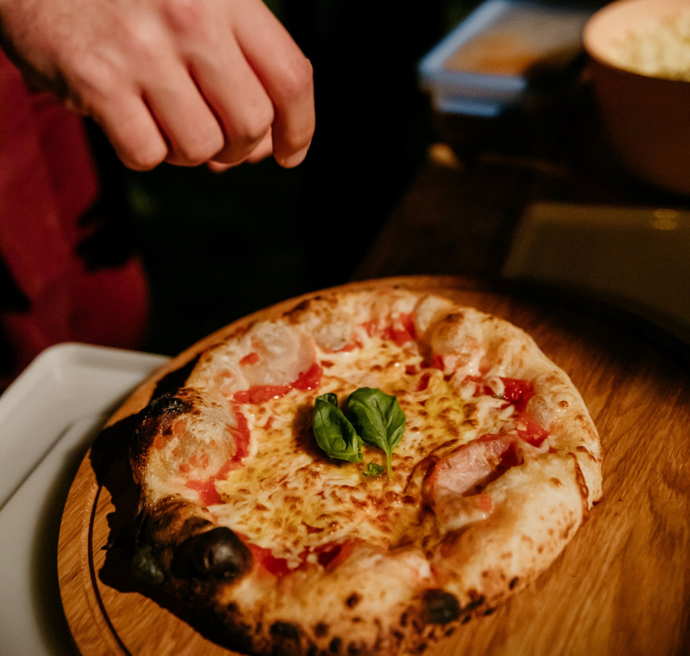 Pizza die vers gebakken is met basilicum.
