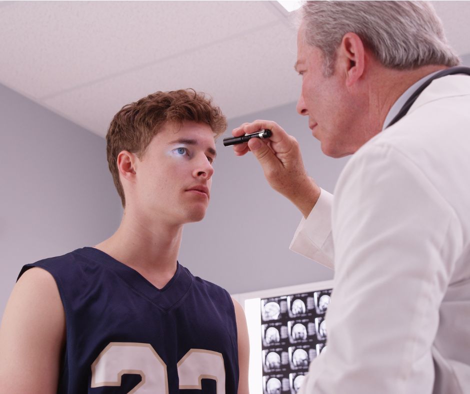 Young male athlete visiting doctor for concussion