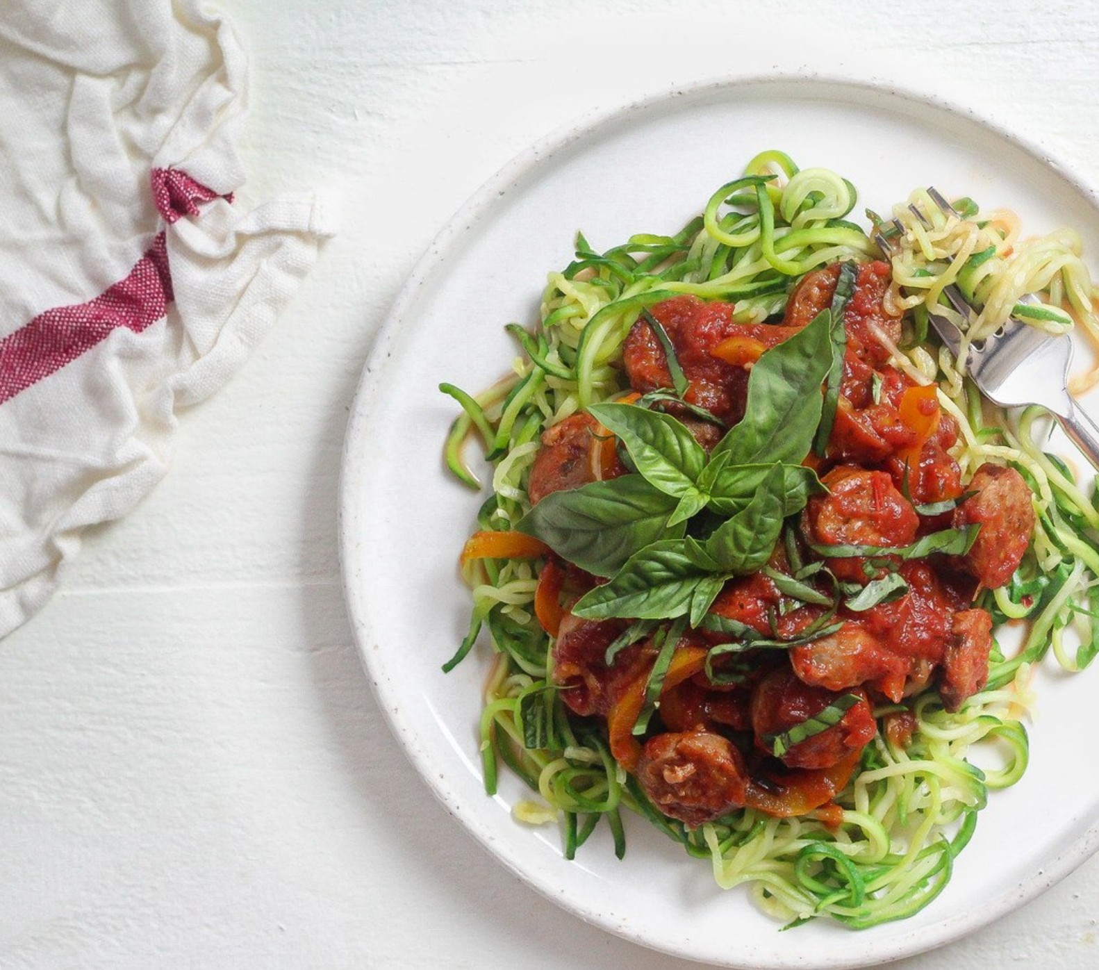 Zucchini noodles topped with savory sausage and tomato sauce—grain-free, low-carb, and ideal for hormone balance.