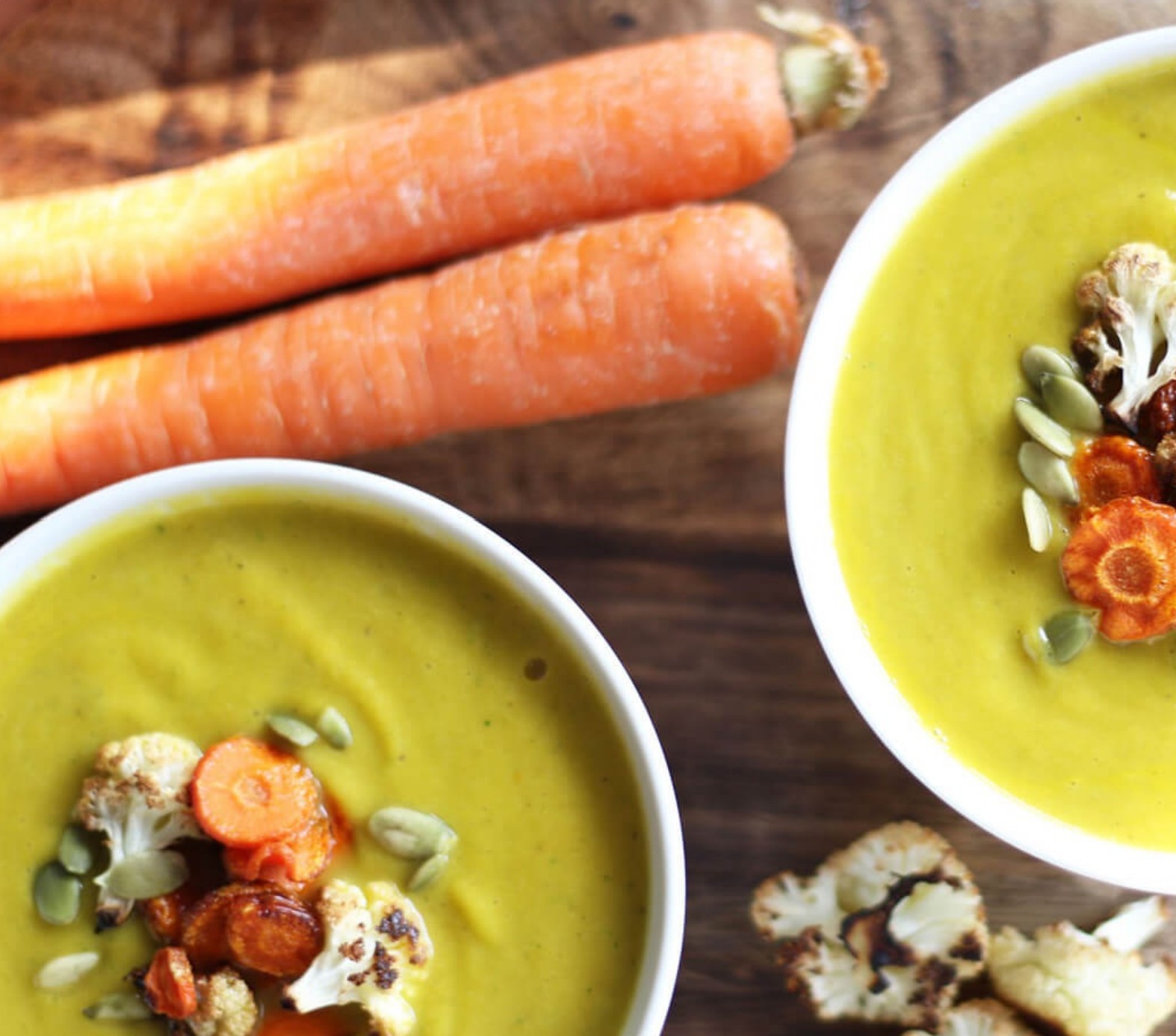 A bowl of creamy cauliflower and carrot soup, garnished with fresh herbs—an anti-inflammatory, gut-soothing meal.