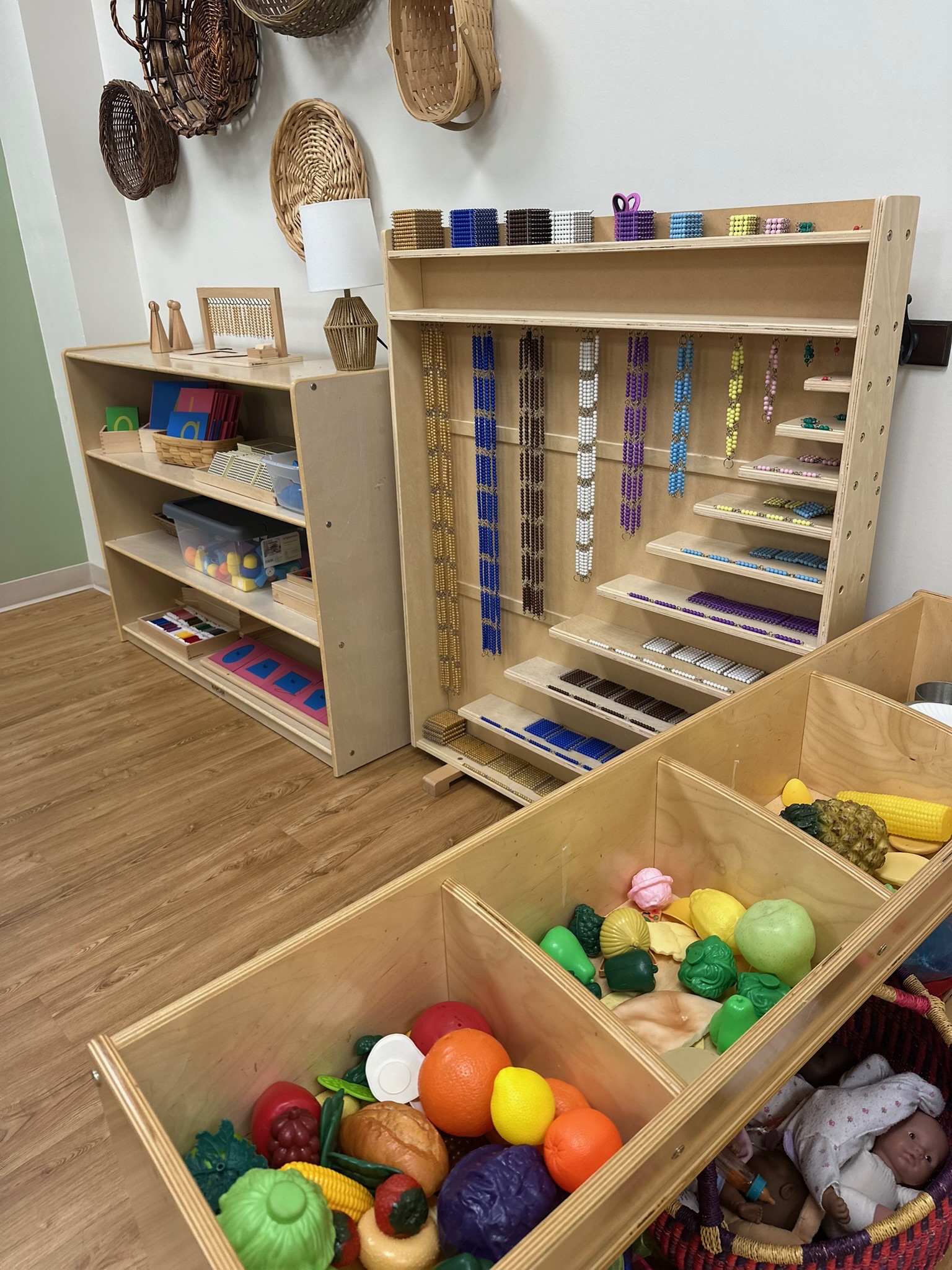 Montessori math and practical life materials arranged on open shelves in a calm preschool classroom at Ivybrook Academy Mount Pleasant.